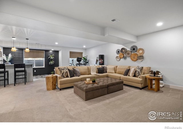 living area featuring baseboards, recessed lighting, visible vents, and light colored carpet