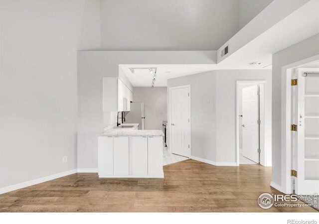 kitchen featuring light countertops, light wood-style flooring, visible vents, and white cabinetry