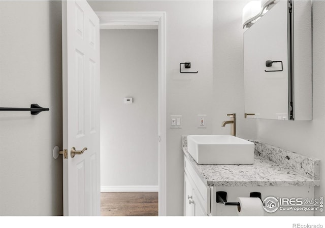 bathroom featuring wood finished floors, vanity, and baseboards