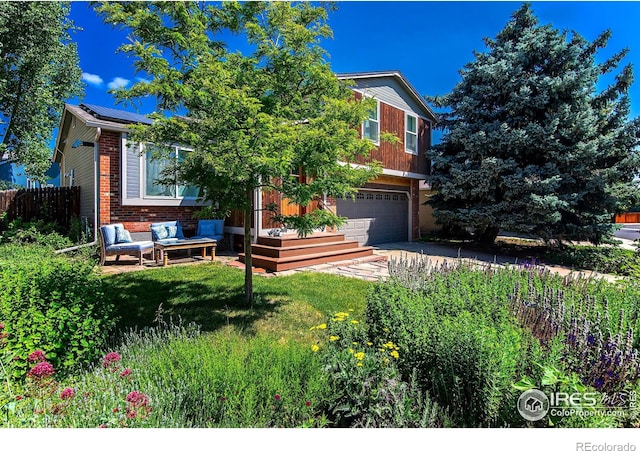 view of property hidden behind natural elements featuring solar panels, brick siding, fence, driveway, and a front lawn