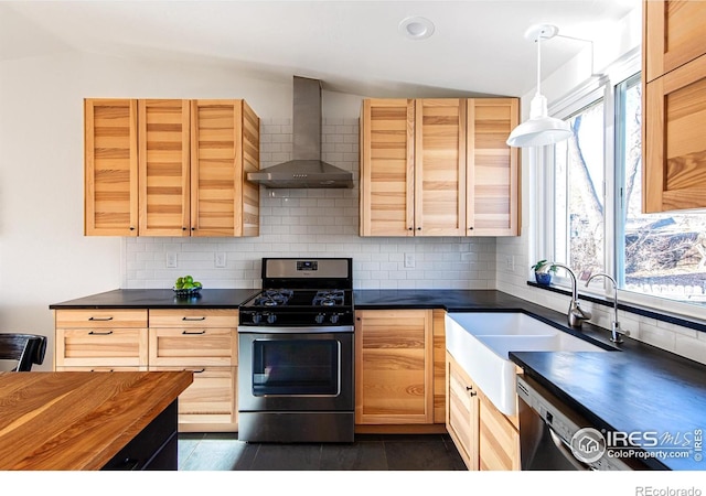 kitchen featuring lofted ceiling, wall chimney exhaust hood, a sink, stainless steel gas range, and backsplash