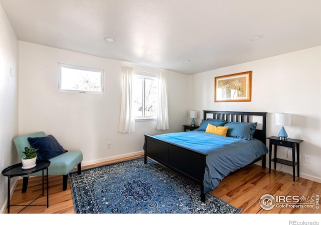 bedroom with baseboards and wood finished floors