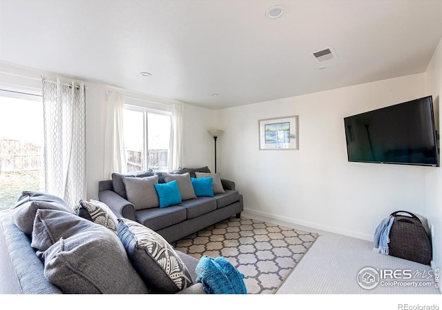 living area with carpet floors, baseboards, and visible vents