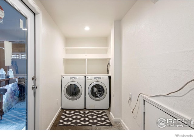 clothes washing area featuring laundry area, washer and clothes dryer, and baseboards