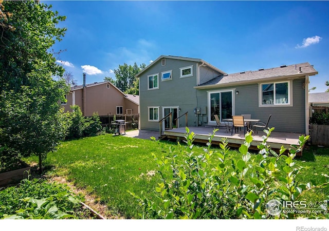 back of property featuring a deck, a yard, and fence