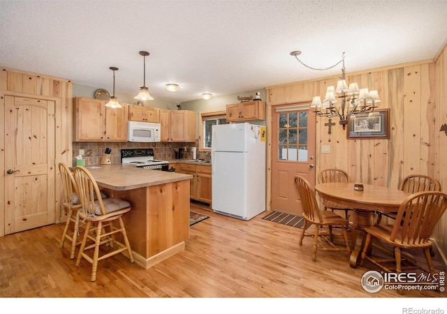 kitchen with light countertops, white appliances, a peninsula, and light wood-style flooring