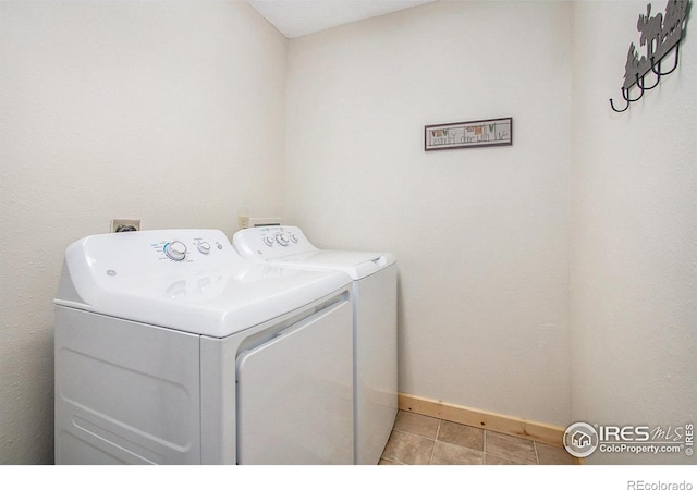 washroom featuring baseboards, laundry area, light tile patterned floors, and washer and dryer