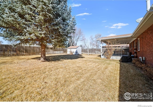 view of yard with a shed, an outdoor structure, and a fenced backyard