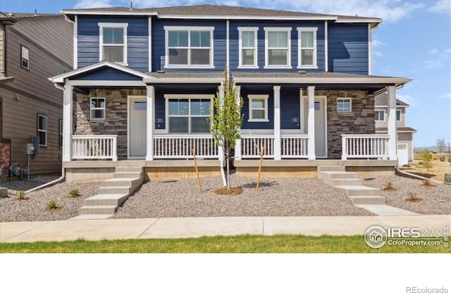 view of front of home with stone siding and a porch