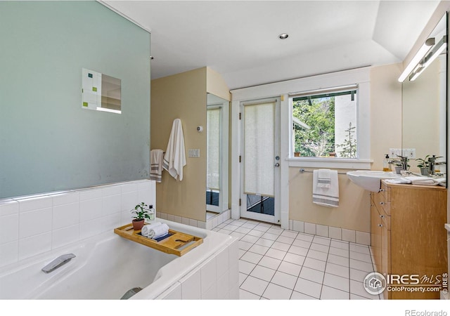 bathroom featuring vanity, a bath, and tile patterned floors