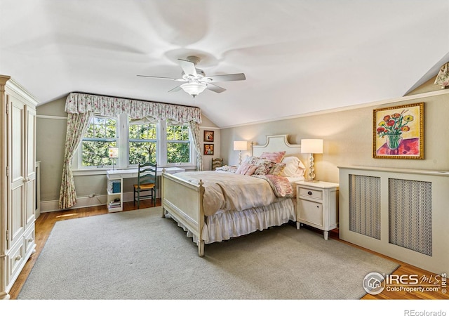 bedroom featuring light wood-style floors, ceiling fan, and vaulted ceiling