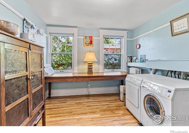 washroom with baseboards, laundry area, washing machine and clothes dryer, and light wood-style floors