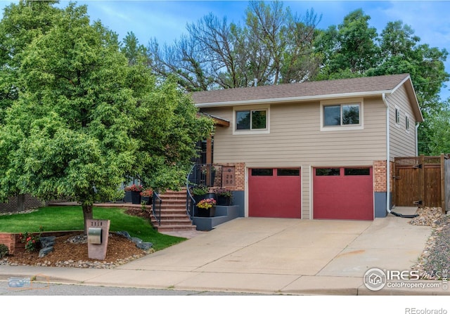 view of front of house with a garage, brick siding, driveway, and stairway