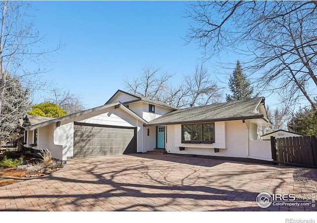 view of front of house with a garage, fence, and driveway