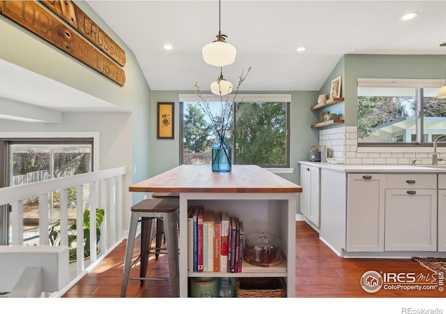 dining room with vaulted ceiling, dark wood-type flooring, and recessed lighting