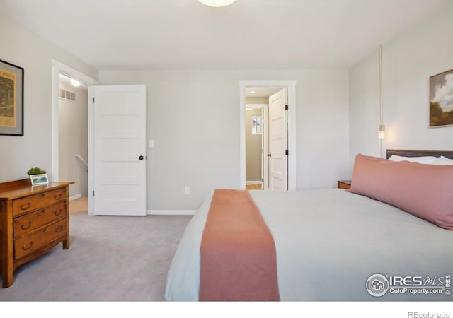 bedroom featuring visible vents, light carpet, and baseboards