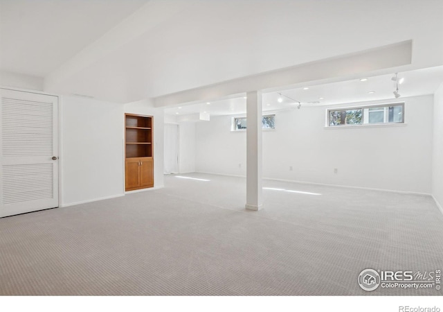 below grade area featuring carpet flooring and baseboards