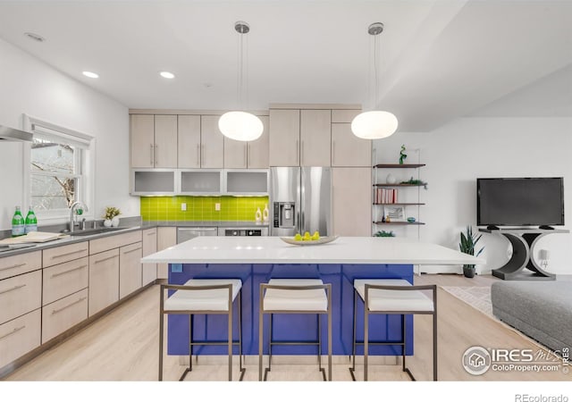 kitchen with stainless steel fridge with ice dispenser, a kitchen breakfast bar, a sink, open shelves, and backsplash