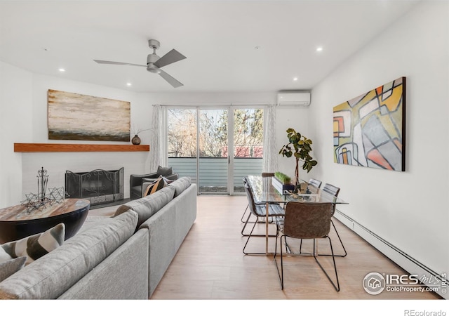 living room with light wood-style floors, a fireplace, baseboard heating, and a wall mounted AC