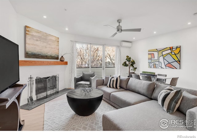 living room with recessed lighting, a wall mounted air conditioner, wood finished floors, and a brick fireplace