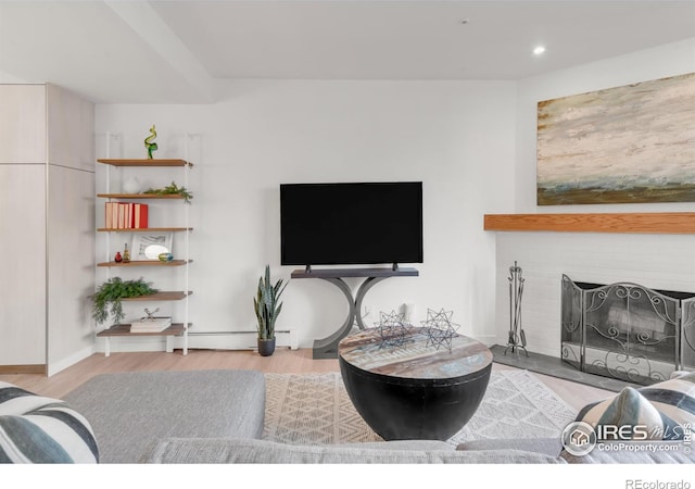 living room featuring a baseboard heating unit, recessed lighting, a fireplace, and wood finished floors