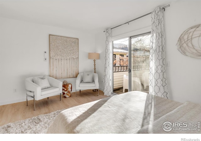 bedroom featuring access to outside, wood finished floors, and baseboards