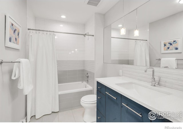 full bathroom featuring toilet, tiled shower / bath combo, vanity, visible vents, and tile patterned floors