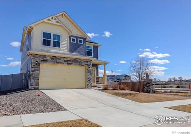 view of front facade with stone siding, fence, concrete driveway, and an attached garage