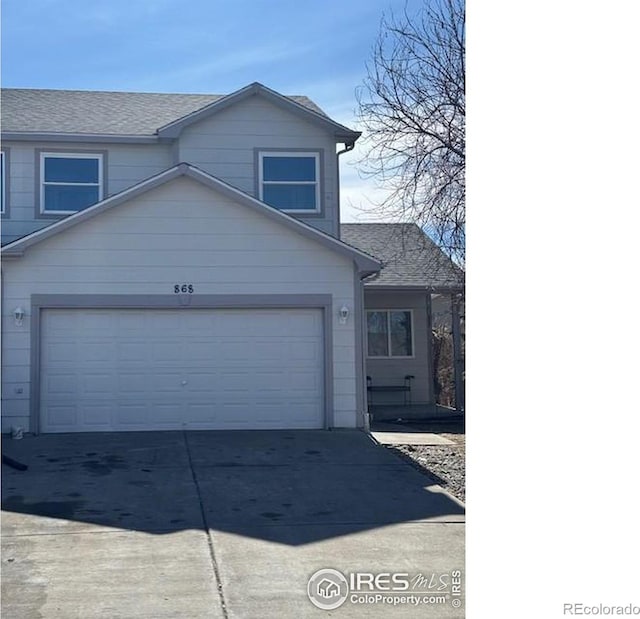 view of front of property with driveway and roof with shingles