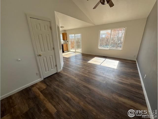 empty room featuring lofted ceiling, a ceiling fan, baseboards, and dark wood-type flooring