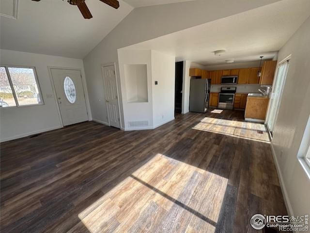 foyer entrance with vaulted ceiling, baseboards, and dark wood finished floors