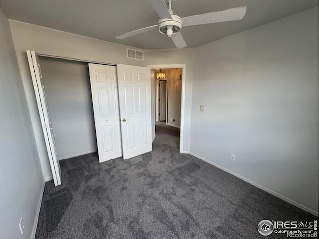 unfurnished bedroom featuring a closet, visible vents, dark carpet, and baseboards