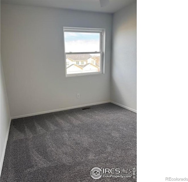 unfurnished room with carpet floors, visible vents, and baseboards