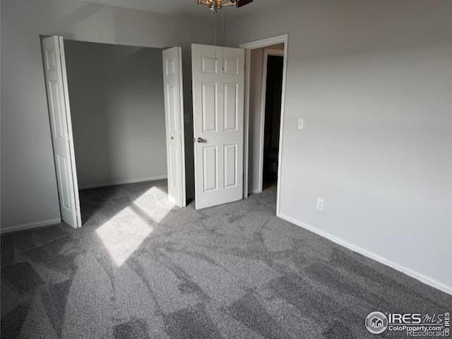 unfurnished bedroom featuring carpet, baseboards, and a closet