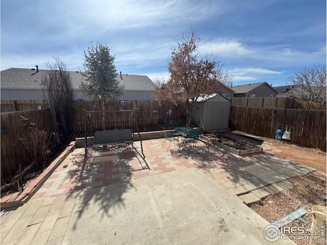 view of patio with a fenced backyard, a storage unit, and an outbuilding