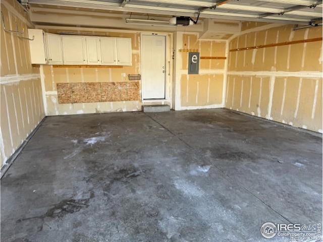 garage featuring electric panel and a garage door opener