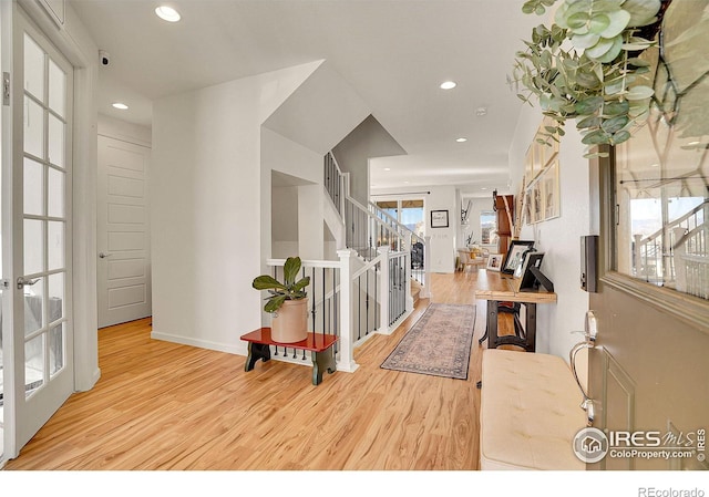 entryway with stairs, french doors, wood finished floors, and recessed lighting