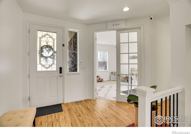 foyer with recessed lighting, french doors, baseboards, and light wood finished floors