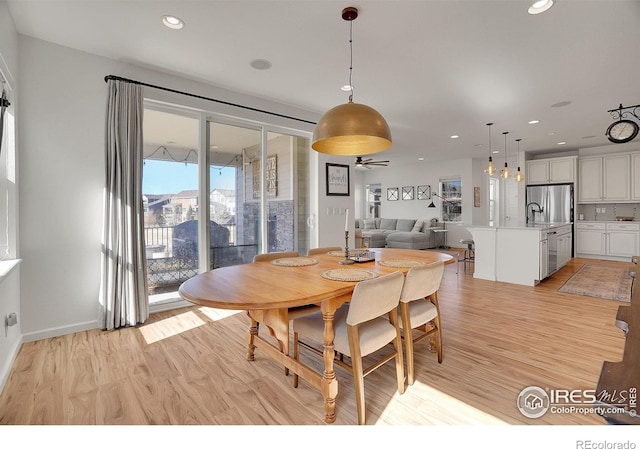 dining space with light wood-style floors, recessed lighting, and baseboards