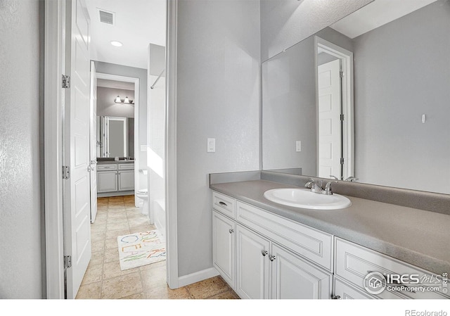 full bathroom with visible vents, toilet, vanity, and baseboards