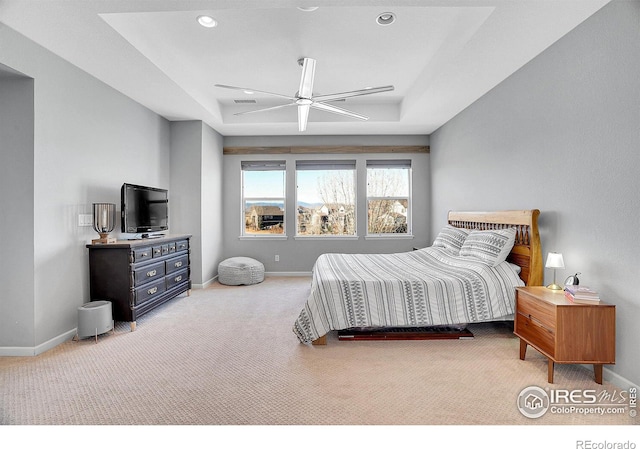 bedroom with baseboards, visible vents, a tray ceiling, carpet floors, and recessed lighting