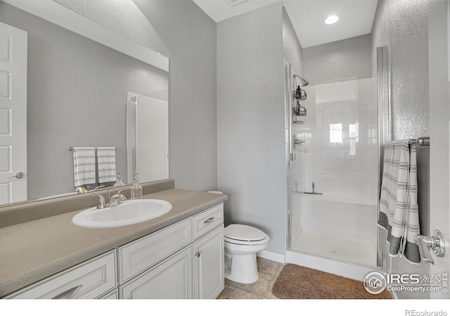 bathroom with toilet, a stall shower, recessed lighting, and vanity