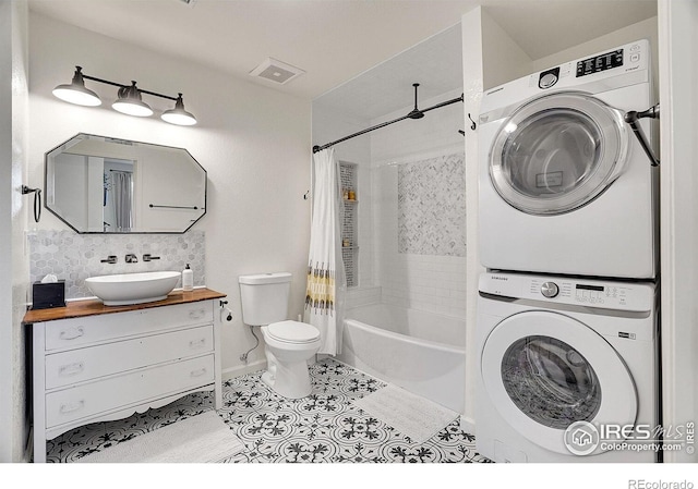 full bath featuring shower / tub combo with curtain, visible vents, toilet, stacked washing maching and dryer, and tile patterned flooring