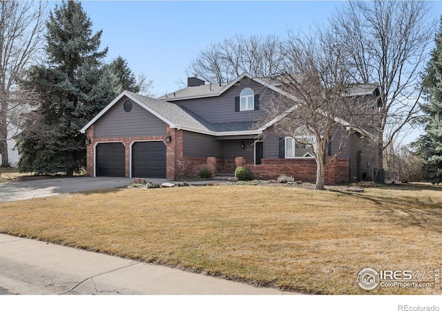 traditional-style house featuring a front yard, concrete driveway, brick siding, and a chimney