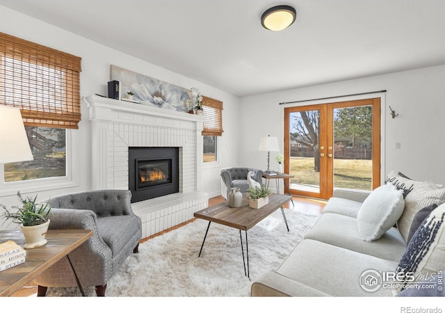 living area with a brick fireplace and french doors