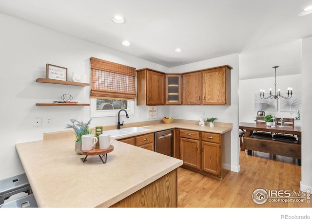 kitchen featuring a sink, a peninsula, brown cabinetry, and light countertops