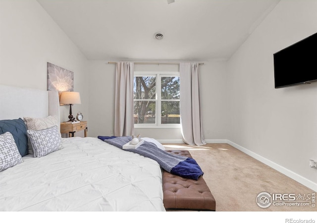 bedroom with visible vents, baseboards, lofted ceiling, and carpet