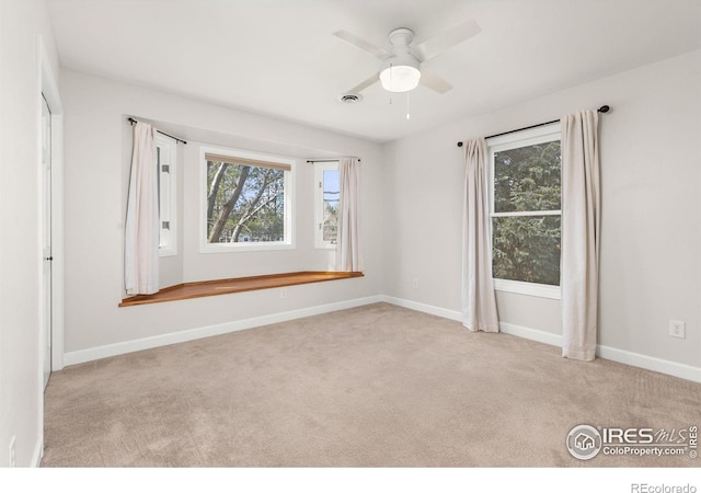 spare room with baseboards, carpet, and a ceiling fan