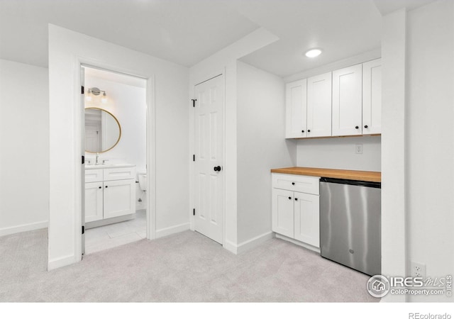 laundry area with light carpet and baseboards