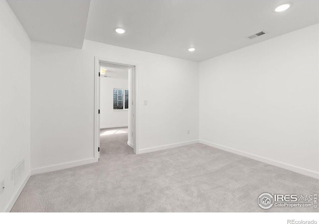 unfurnished room with recessed lighting, visible vents, carpet floors, and baseboards